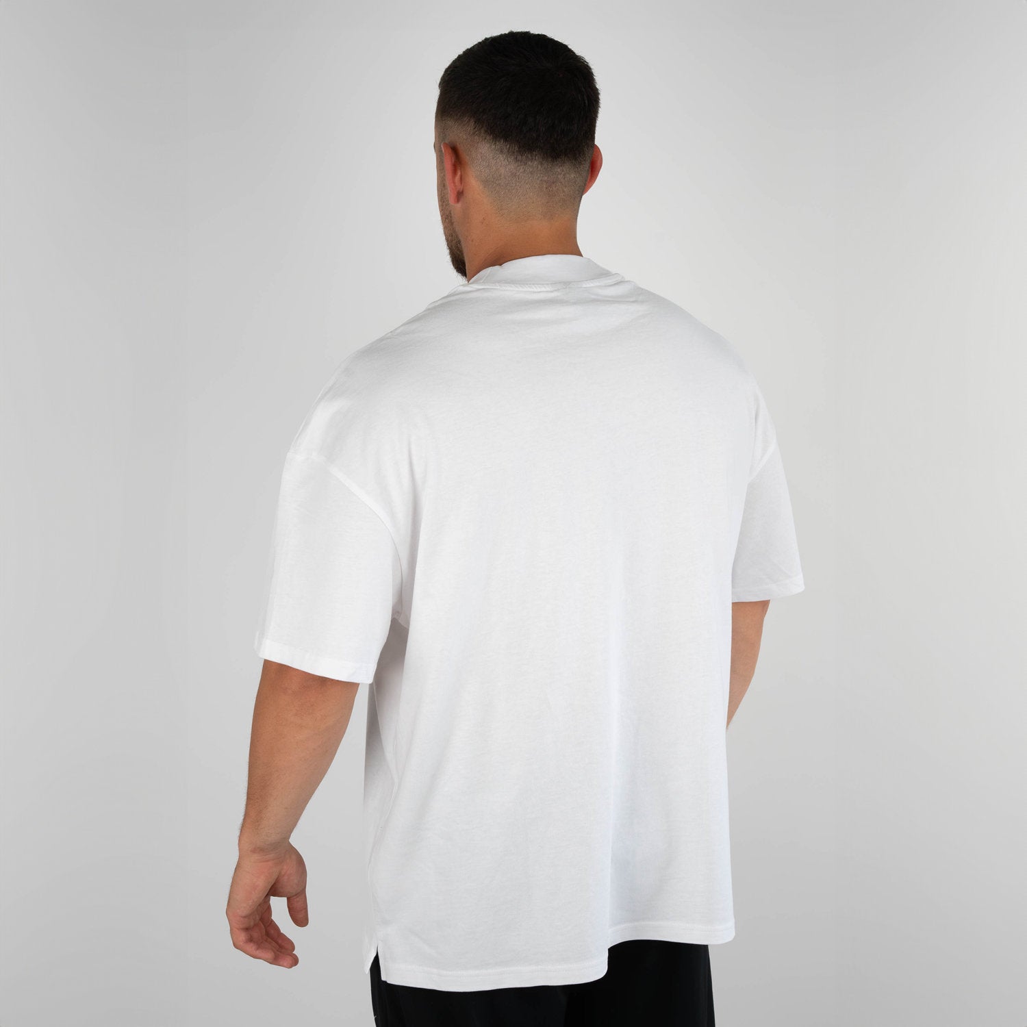 Mann trägt weißes oversized Zec+ T-Shirt Rückseite