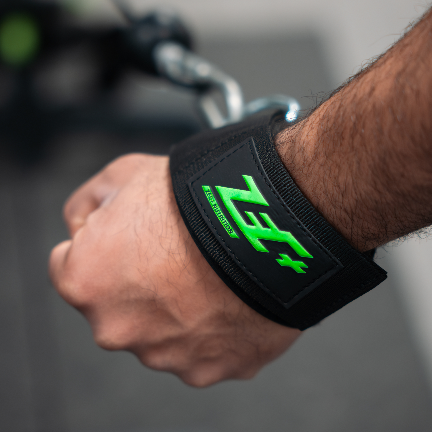 Zecplus Hand Cuffs am Handgelenk Mann beim Training schwarze Manschette mit grünem Logo und Metallring