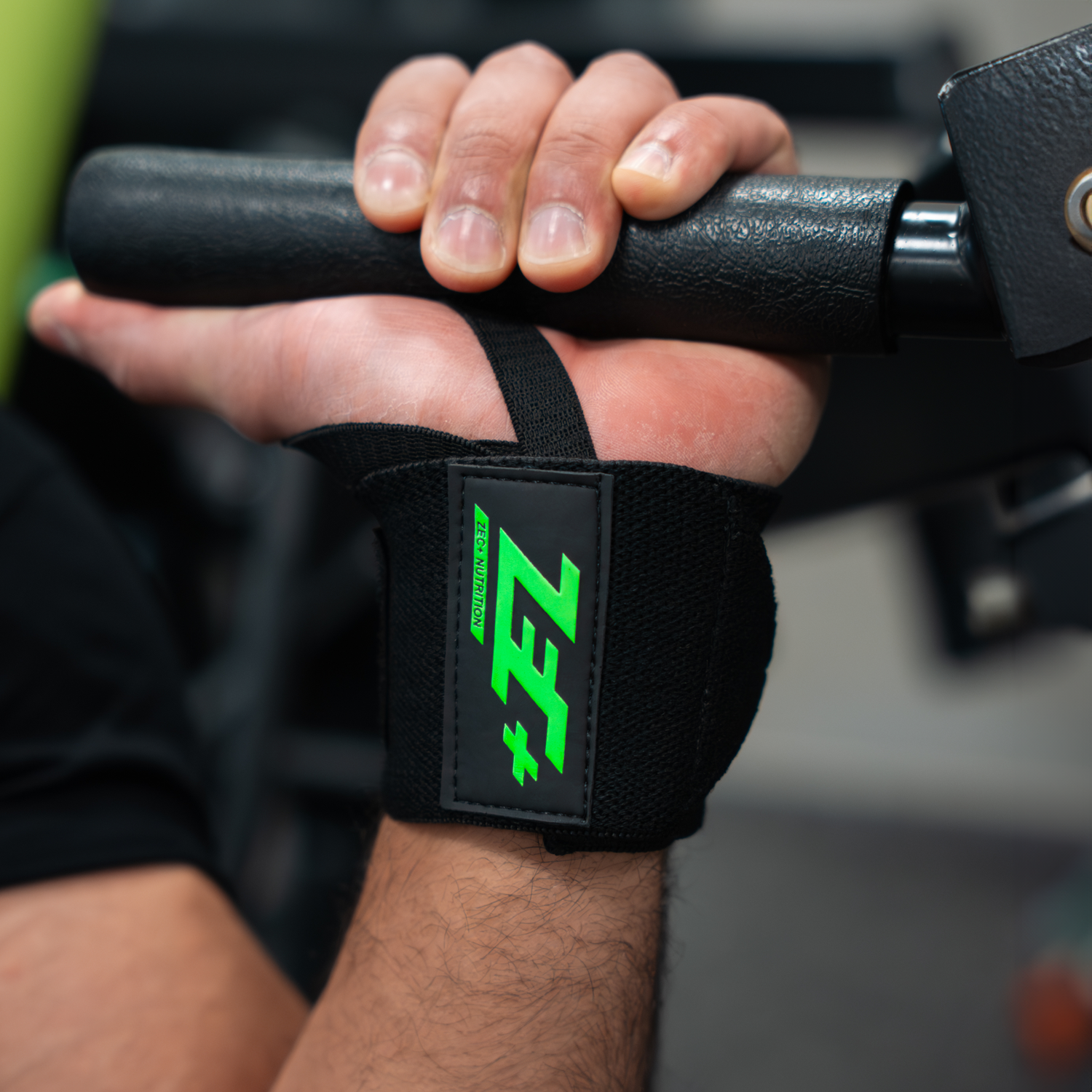 Zec+ Wrist Wrap am Handgelenk, Mann trainiert mit Hantelstange im Fitnessstudio.