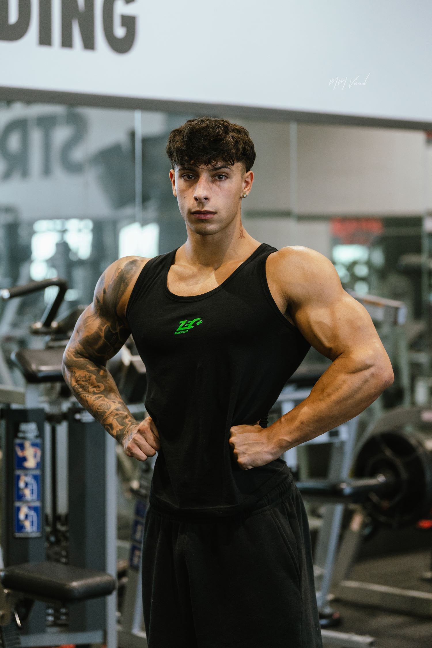 Sportler im schwarzen Zec+ Muskelshirt beim Posing im Fitnessstudio
