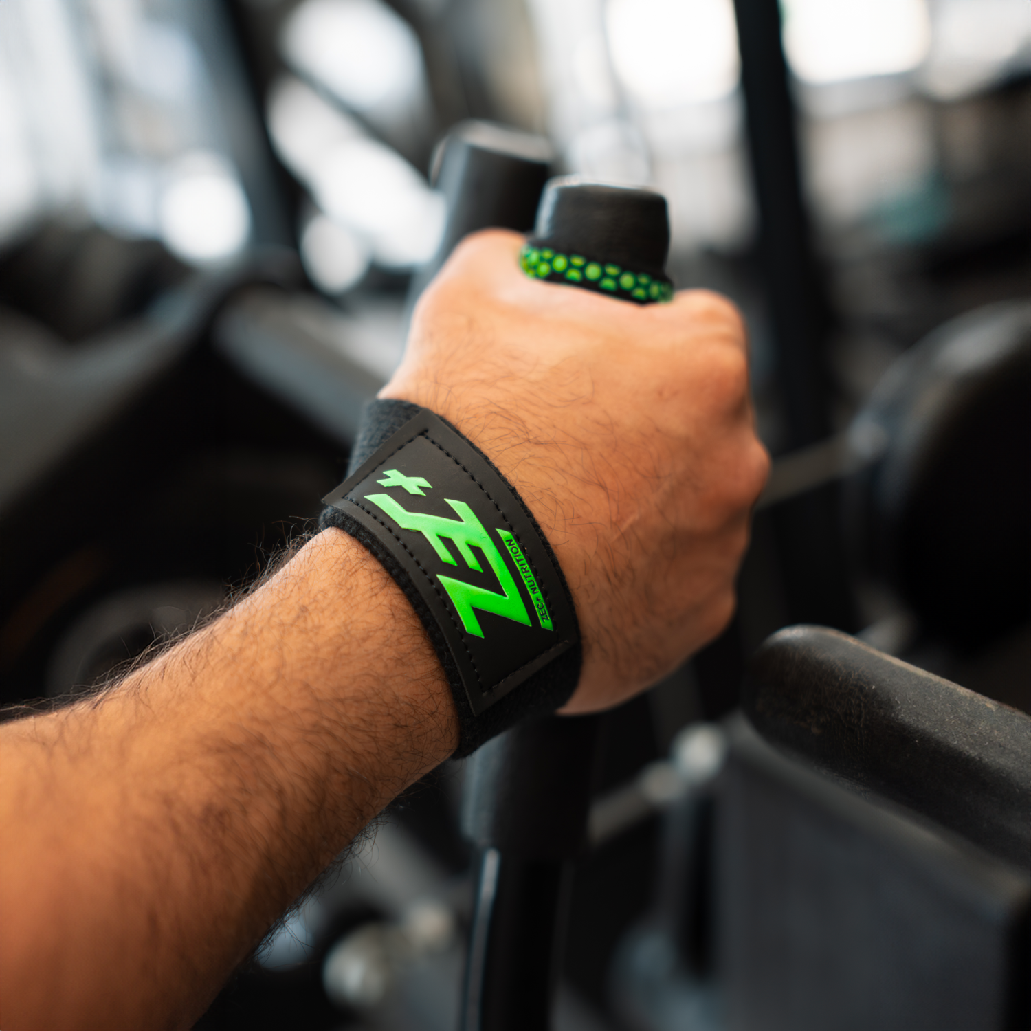 Zec+ Lifting Strap schwarz-grün am Handgelenk eines Mannes beim Gerätetraining
